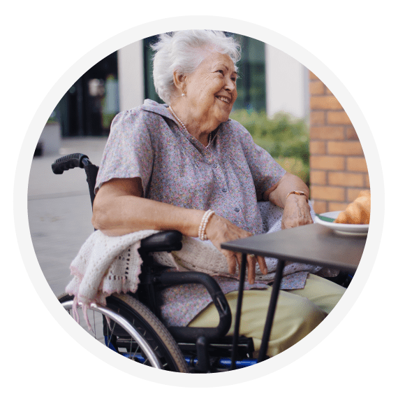 Happy elderly woman in a wheelchair at a cafe